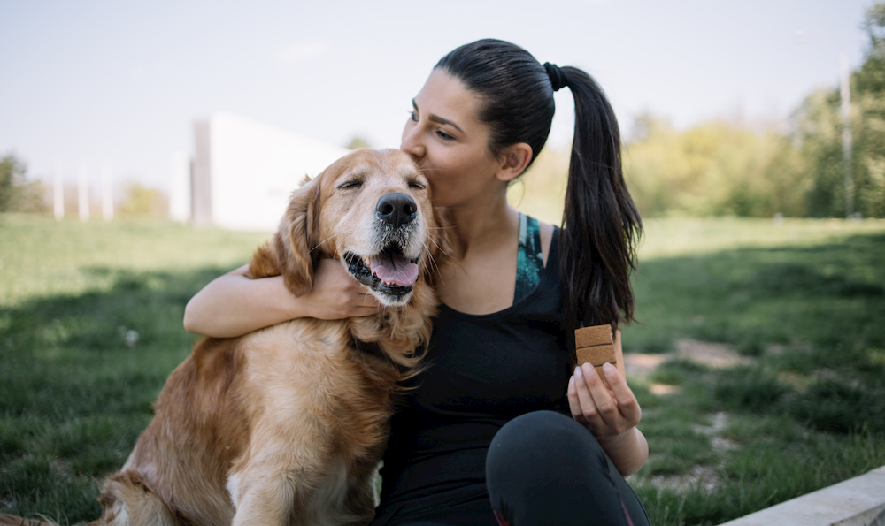 Woman giving dog hip and joint supplement