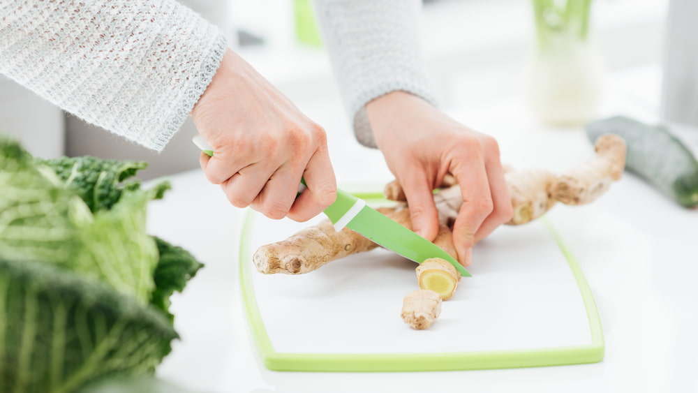 Woman cutting ginger root